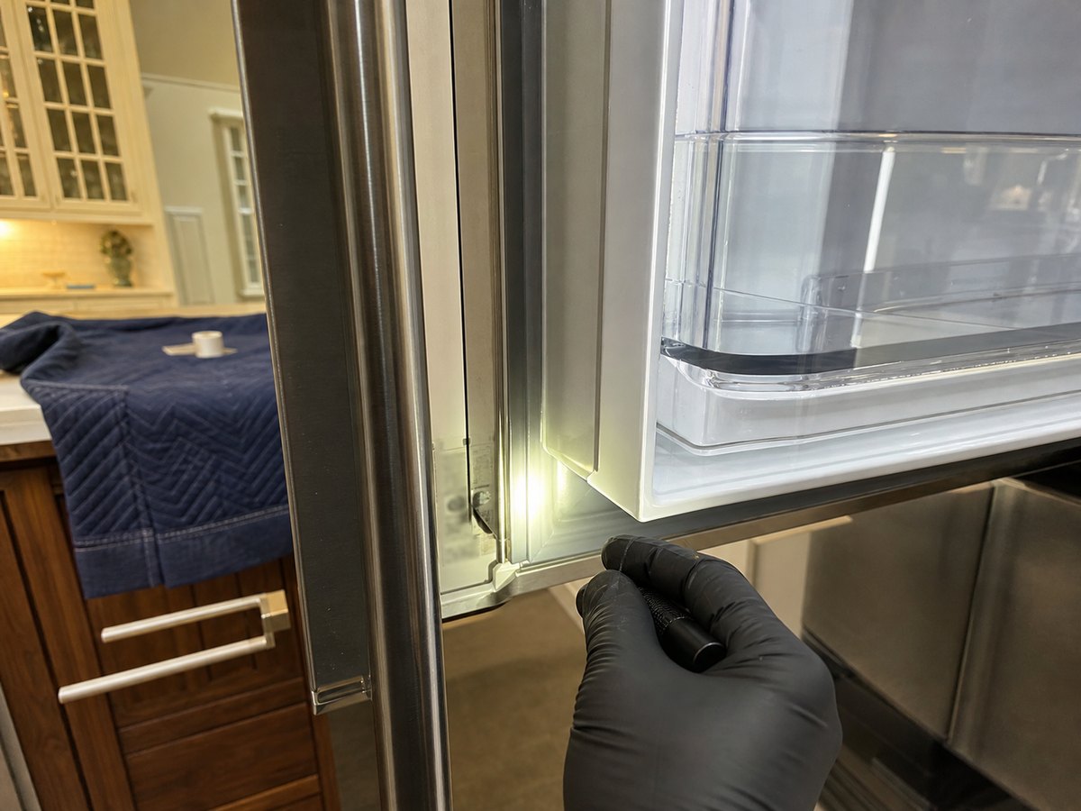 Built-in refrigerator door opened to expose the side frame area where a model tag is commonly checked